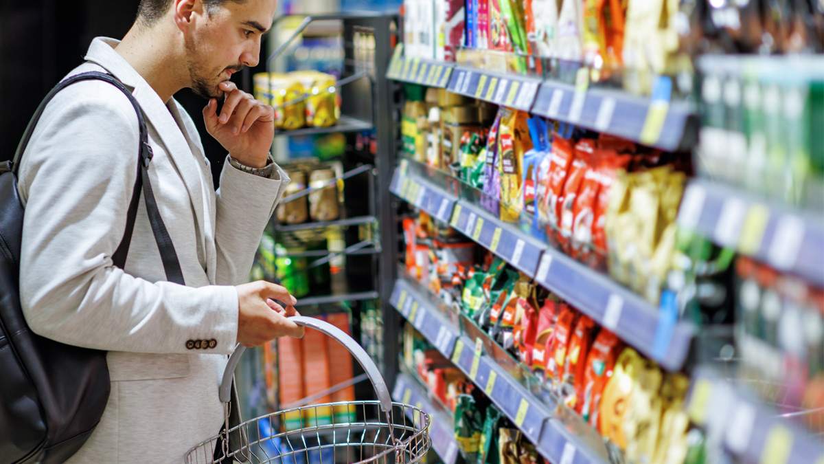 Man looking at different bags on chips on the self